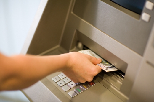 Egy kéz pénzt vesz ki a bankautomatából.